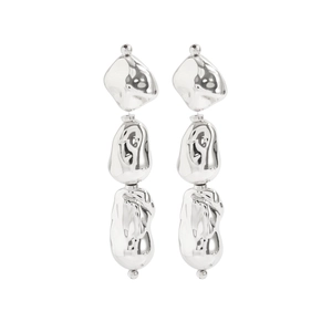 Détail de boucles d'oreilles argentées aux formes irrégulières et au design moderne