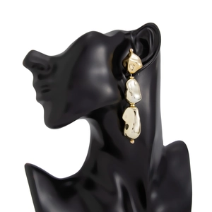 Vue détaillée des boucles d'oreilles dorées à trois couches avec texture ondulée