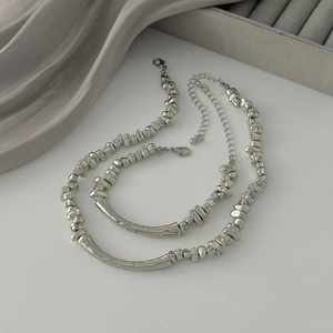 Silver beaded necklace and bracelet set with irregular beads and smooth curved metal tube