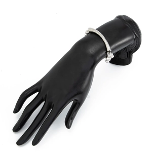 Detailed view of silver textured bangle with wavy metal pattern on a black hand model