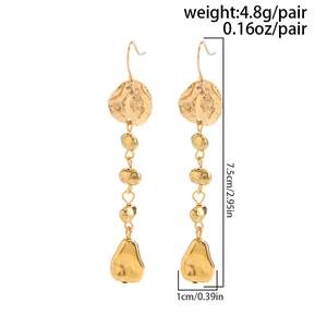 Détail de boucles d'oreilles pendantes dorées avec texture métallique martelée et dimensions