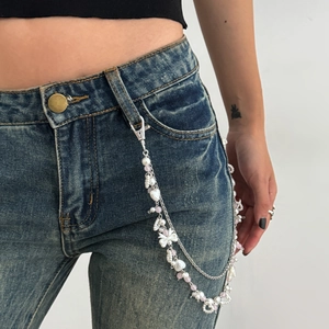Close-up of multilayered Y2K waist chain with pink beads, pearls and heart charms