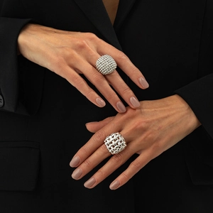 Detail of silver dome textured ring and geometric woven metal ring on model fingers