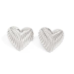 Dettaglio macro di orecchini a cuore argento con elegante trama a righe verticali