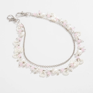 Detail van zilveren ketting met hartparels en roze kralen voor jeans of tassen