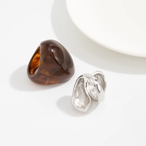 Close-up of amber resin ring with marble swirl and silver hammer-textured metal ring
