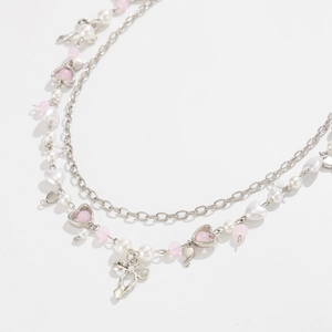 Close-up of balletcore layered chain with pink heart pendant and silver ballet shoes