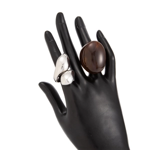 Detail of an organic silver-tone metal ring and translucent brown resin dome ring on display