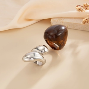Retro resin and silver metal arched ring set on neutral stones with silk fabric