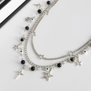 Macro detail of multi-layer punk chain with hollow stars and black pearl charms