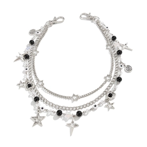 Detail van punk-stijl drielaagse zilveren broekketting met holle sterren en kralen
