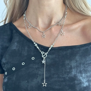 Macro detail of silver double-layer star necklace with T-bar toggle clasp on model