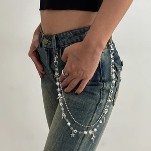 Detail of punk multi-layer waist chain with silver stars, pearls, and heart charms
