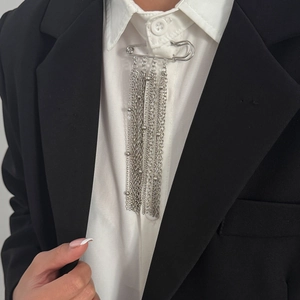Mehrlagige silberne Quastenkette Brosche an weißem Hemd und schwarzem Blazer