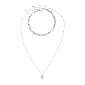 Vue détaillée du pendentif cœur argenté avec couches de chaînes à perles métalliques