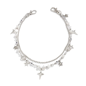 Detail van gelaagde tailleketting met parels, zilveren sterren en hartvormige bedeltjes