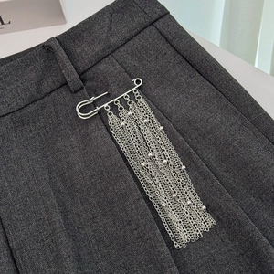 Spilla a balia argento con nappe a catena multistrato su pantaloni da completo
