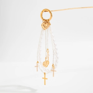 Detail of faux pearl bag charm with golden heart pendants and small crosses