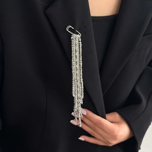 Detail of silver tassel brooch with gray crystal beads pinned on a black suit lapel