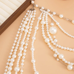 Close-up of layered baroque pearl necklaces showing luster and silver metal clasps