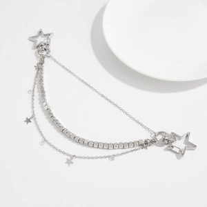 Detail view of multi-layer silver metal chain with stars and transparent beads on white