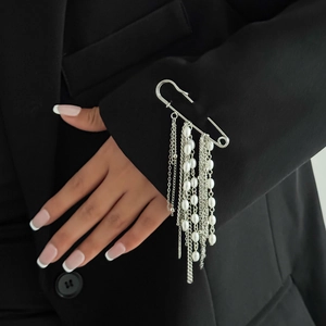 Silver star brooch with multi-layer tassel chains and pearls on a black suit blazer