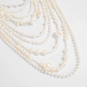 Detail of layered baroque pearl necklace showing varied sizes and silver chain accents
