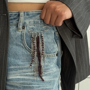 Pentagramm Stern Quaste Kette Brosche mit burgunderroten Perlen auf blauer Jeans