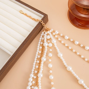 Detail of multi-layer baroque pearl necklace set with golden chains and lobster clasp