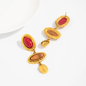 Close-up of vintage gold hammered drop earrings with red and brown oval stones