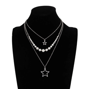 Close-up of triple-layered silver necklace with sparkling star pendants and metal beads