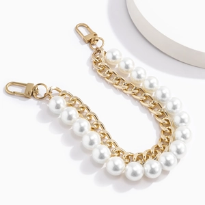 Detail of double-layer bag chain featuring faux pearls and golden metal links