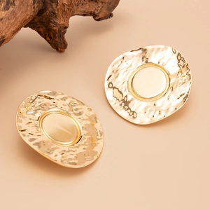 Detail of large gold plated round stud earrings with unique hammered texture and geometric design