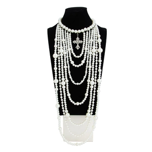 Detail van de meerlaagse parelketting met een fonkelende kruis hanger van strass