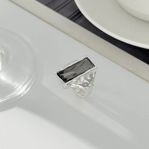 Dettaglio anello argento con pietra grigia taglio smeraldo e fascia effetto lava