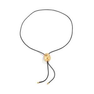 Detalle de un colgante de guijarro dorado pulido en un cordón negro con puntas de metal