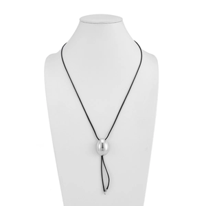 Primer plano detallado del colgante de plata pulida en un collar de cordón negro minimalista