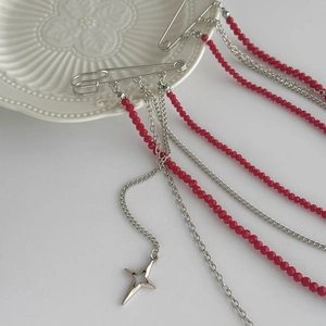 Détail d'une broche hip-hop avec chaînes de perles rouges et pendentif étoile ajouré