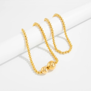 Detail van meerlagige gouden kralenketting met gepolijste afwerking op standaard