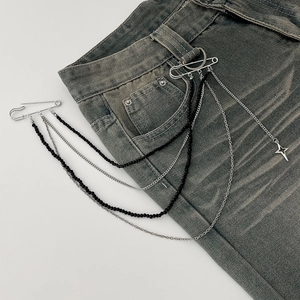Chaîne de ceinture punk avec pendentif étoile, perles noires et métal sur un jean