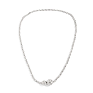 Detail van de zilveren kralenketting met gelaagde metalen bollen en gepolijste glans