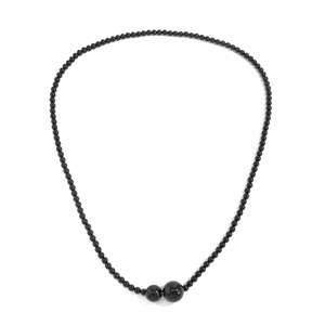 Detailopname van de zwarte kralenketting met glanzende grote dubbele ronde kralen