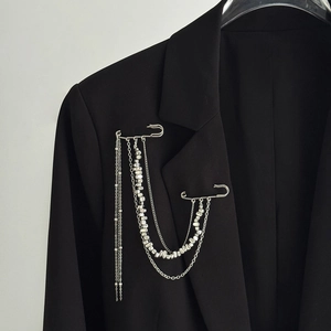 Close-up of multi-layer silver fringe chain brooch with pins on a black suit jacket