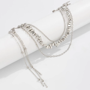 Macro view of multi-layered silver metal chains and punk style irregular beads on jewelry