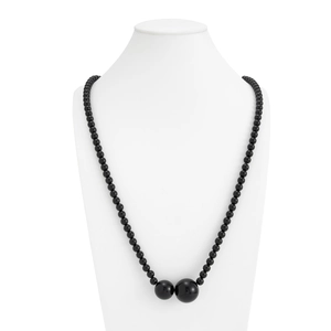 Detail van glanzende zwarte kralenketting met grote centrale kralen op witte buste