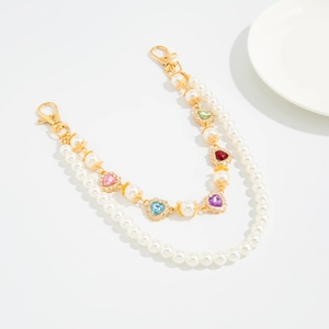 Detail of double-layer pearl chain with colorful crystal heart charms and gold lobster clasps