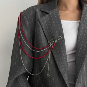 Gothic style layered chain brooch with red beads and star pendant on a suit lapel