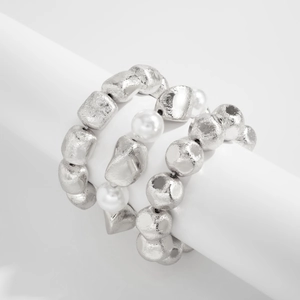 Macro detail of three-piece stretch beaded bracelets with silver-tone textured beads and pearls