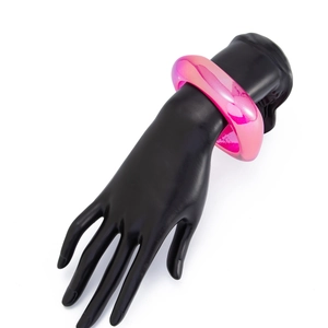 Nahaufnahme der dicken rosa Harz-Armreif mit Glitzer auf einer schwarzen Modelhand
