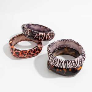 Gros plan de gros bracelets rétro en résine avec des motifs animaliers léopard et zèbre